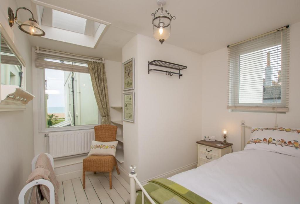 um quarto com uma cama, uma cadeira e uma janela em Victorian Cottage - The Beach Walmer em Walmer