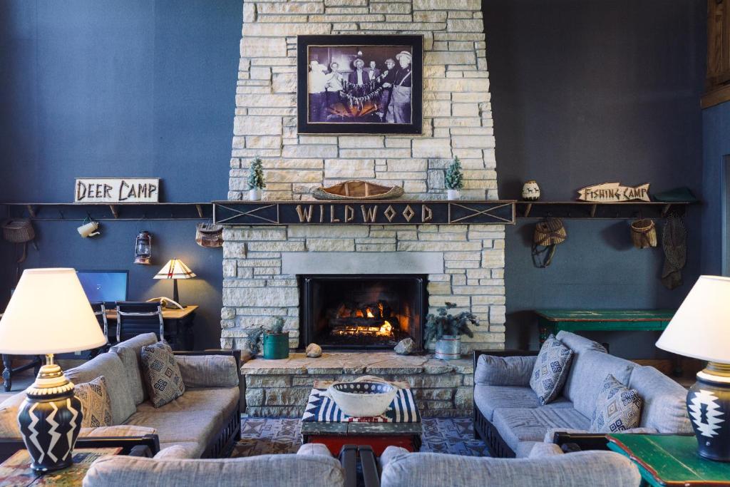 a living room with couches and a fireplace at Wildwood Lodge & Suites in Clive