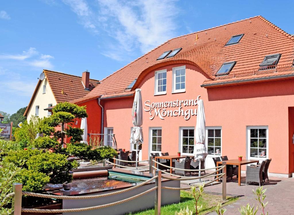 a hotel with a swimming pool in front of a building at Ferienwohnungen Moenchgut und Ruegen in Lobbe