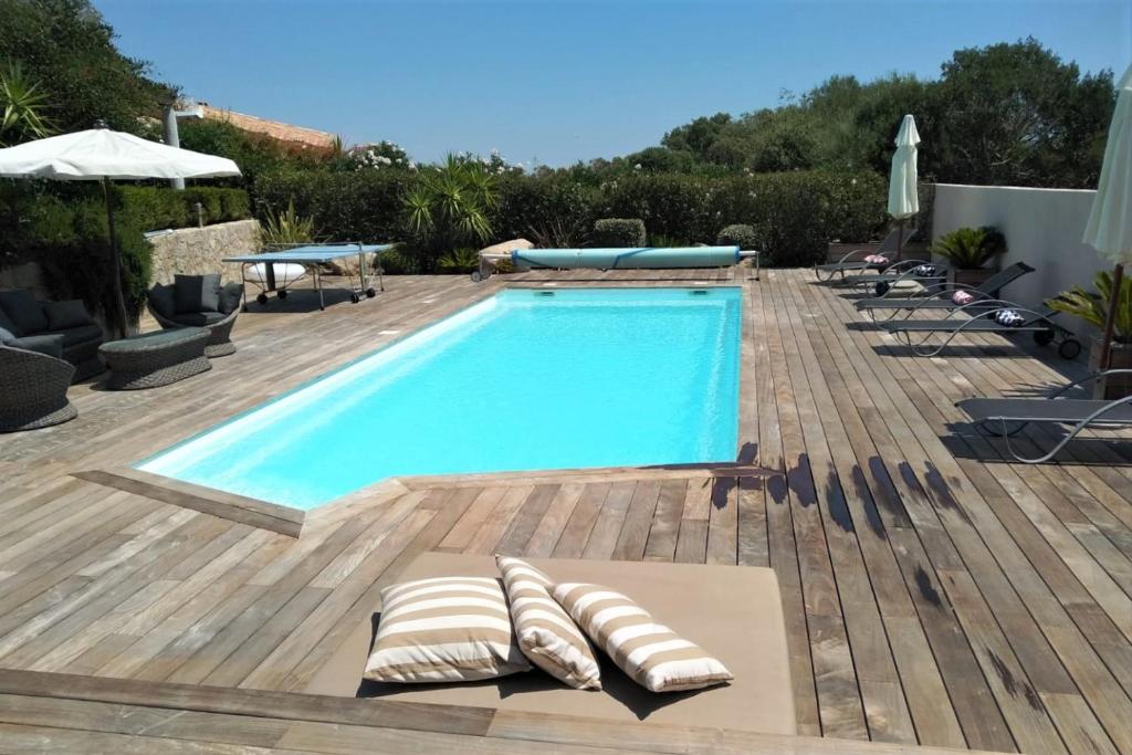 - une piscine avec chaises longues sur une terrasse en bois dans l'établissement Villa RIVIERA, à Porto-Vecchio