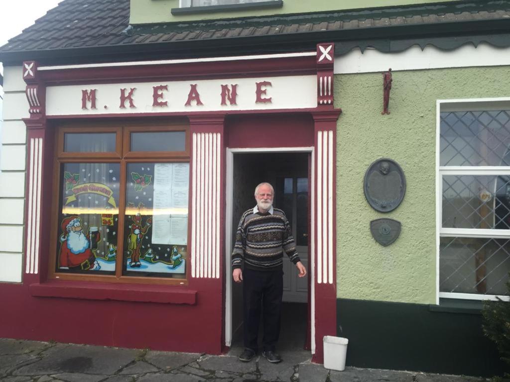 um homem parado na porta de uma loja de meyer em Keane's Bar & Restaurant em Blackweir Bridge