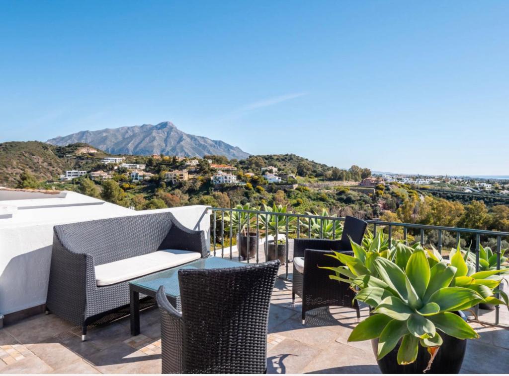 een patio met rieten stoelen en een tafel met uitzicht bij LUXURY 3 BEDROOM HOUSE AT LA QUINTA GOLF COURSE OCEAN and MOUNTAIN VIEW in Benahavís