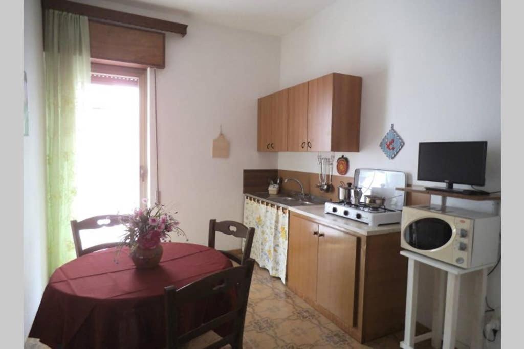a kitchen with a table and a small kitchen with a table and a window at CASA Spezie 1PD in Castellammare del Golfo