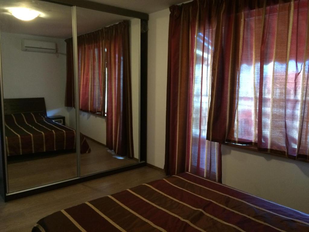 sypialnia z lustrem, łóżkiem i oknem w obiekcie 2-х комнатные апартаменты в г.Поморие Болгария w mieście Pomorie