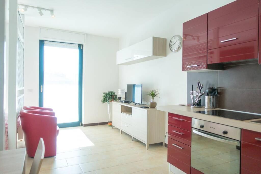 kuchnia z czerwonymi szafkami i czerwonym krzesłem w obiekcie Apartment Victoria, cozy studio flat near Leonardo Academy w mieście Sesto Calende