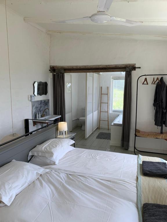 1 dormitorio con 1 cama blanca grande en una habitación en Kleinkloof Farm, en Piketberg