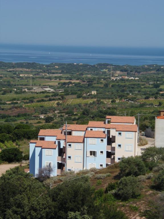 un edificio en una colina con el océano en el fondo en Nonsolomare BADESI, en Badesi