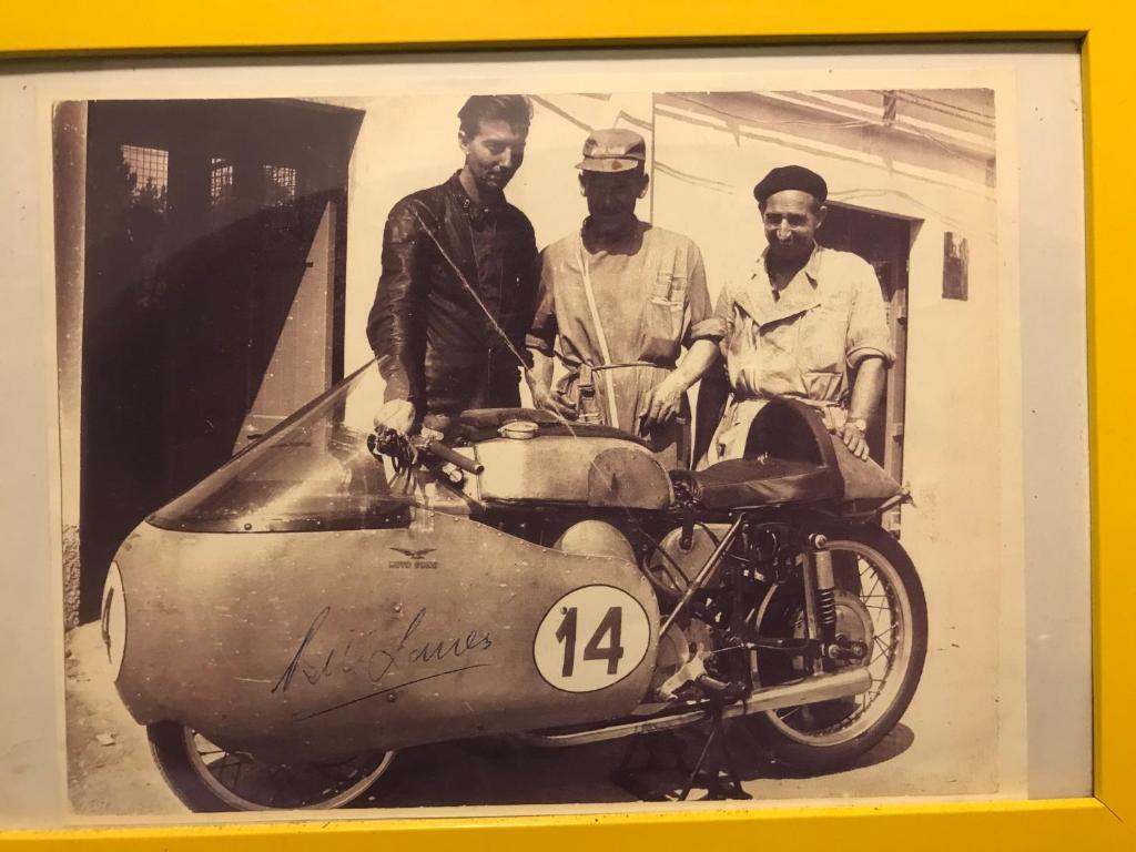 3 Männer stehen neben einem Motorrad mit Beiwagen in der Unterkunft B&B " Guzzi - Inn " in Mandello del Lario