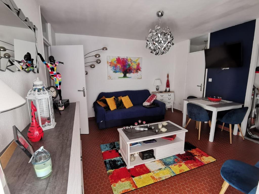 un salon avec un canapé bleu et une table dans l'établissement Appartement Charmant à Collioure, à Collioure