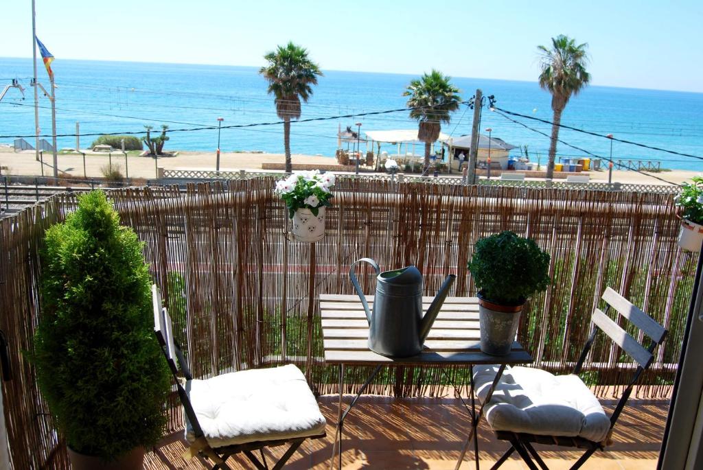 un patio con mesa y sillas y la playa en Panier en Osier · Panier en Osier · Charming apartment w/private terrace 2min from sea en Vilassar de Mar