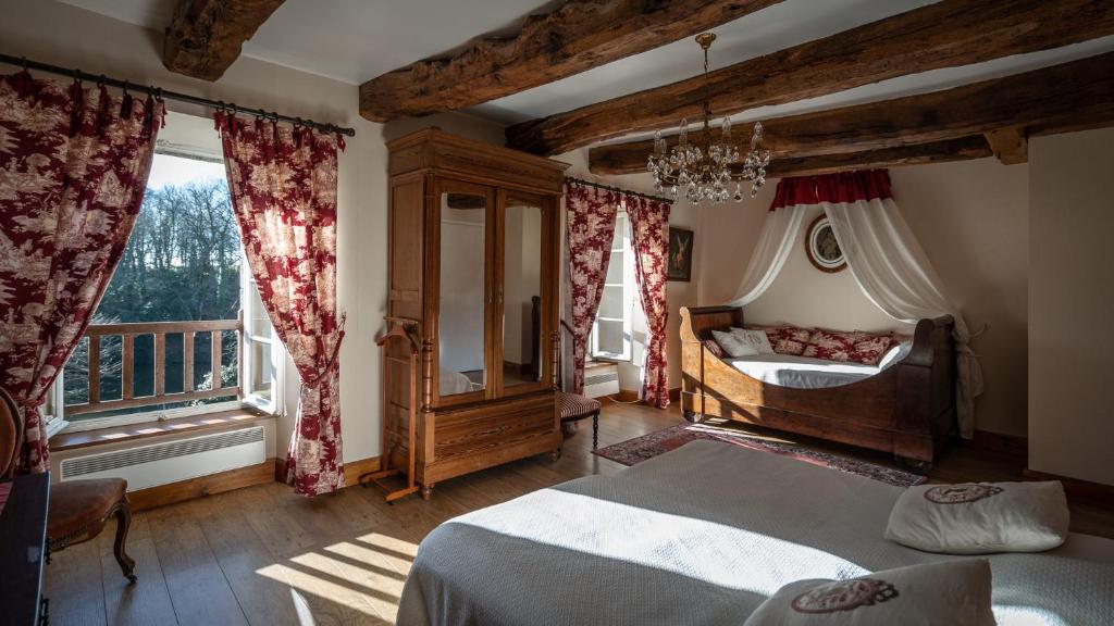 sypialnia z 2 łóżkami i oknem w obiekcie Manoir du Plessix Méen w mieście Pluduno