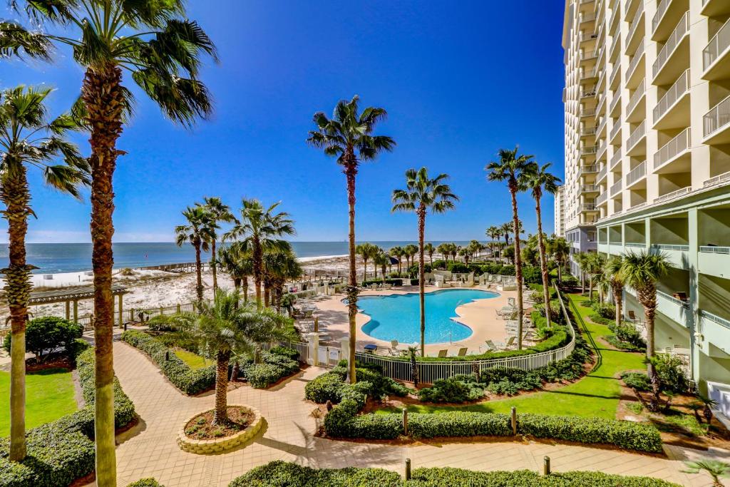 an aerial view of a resort with a pool and palm trees at The Beach Club Resort and Spa in Gulf Shores