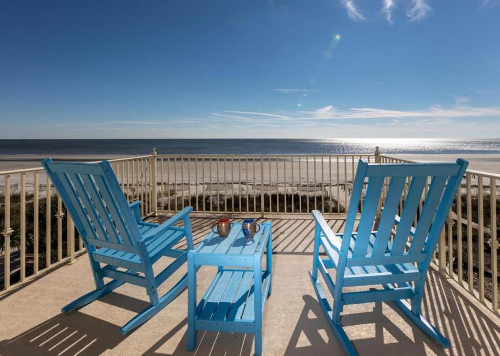 2 sillas azules sentadas en un balcón con vistas a la playa en 61 Dune Lane, en Hilton Head Island