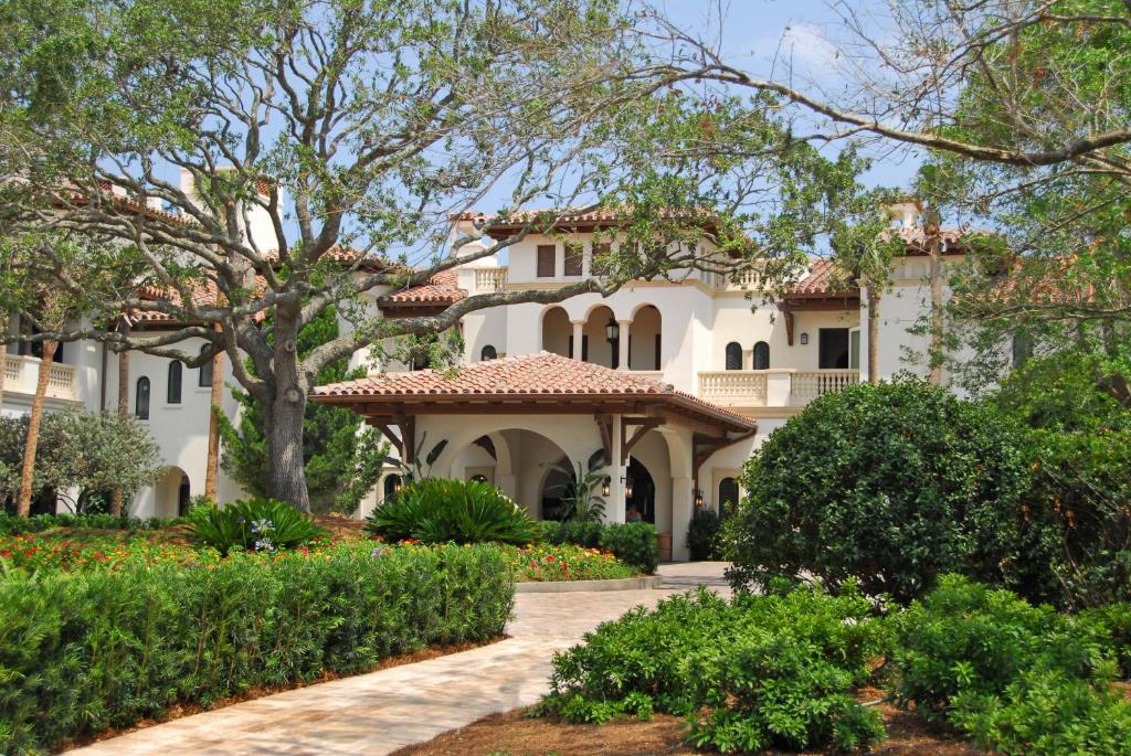 a large white house with a garden and trees at The Cloister in Sea Island