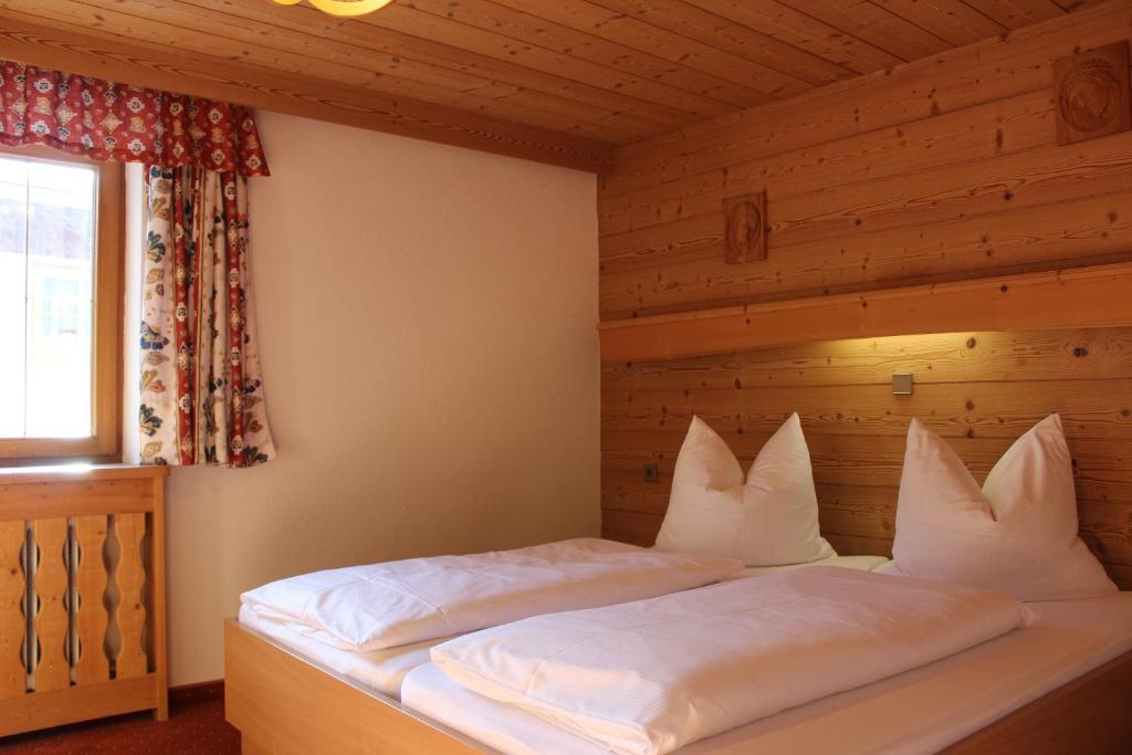 łóżko w pokoju z drewnianą ścianą w obiekcie Haus Brandhofer w mieście Häselgehr