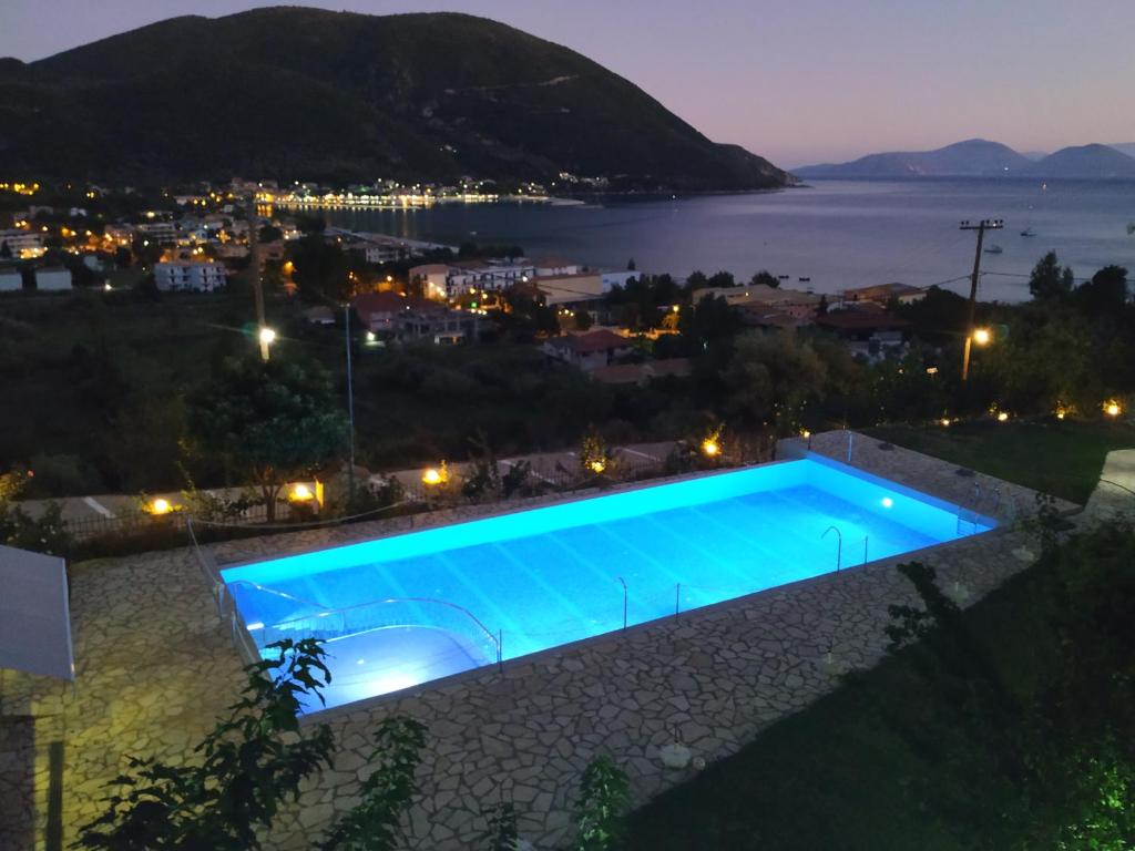 a swimming pool at night with a view of a city at Katerina Lefkada in Vasiliki