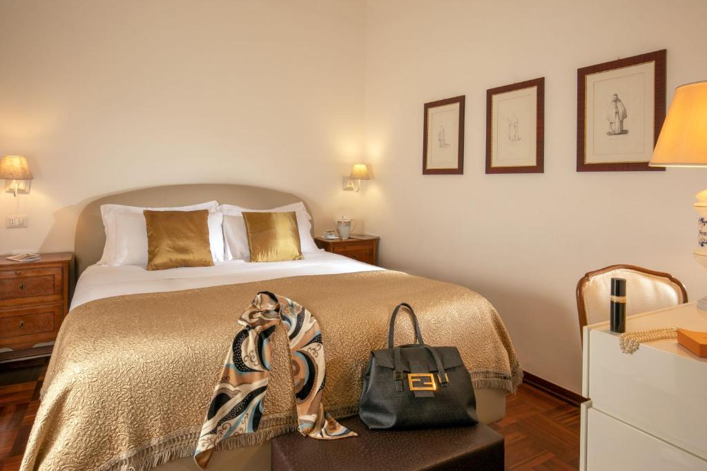 a bedroom with a bed with a bag on a table at Riccardo Condotti Suite in Rome
