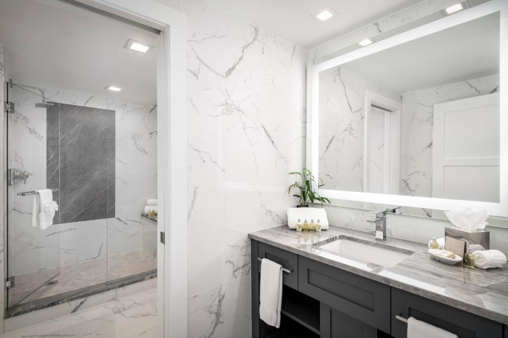 a white bathroom with a sink and a shower at Inn On Fifth in Naples