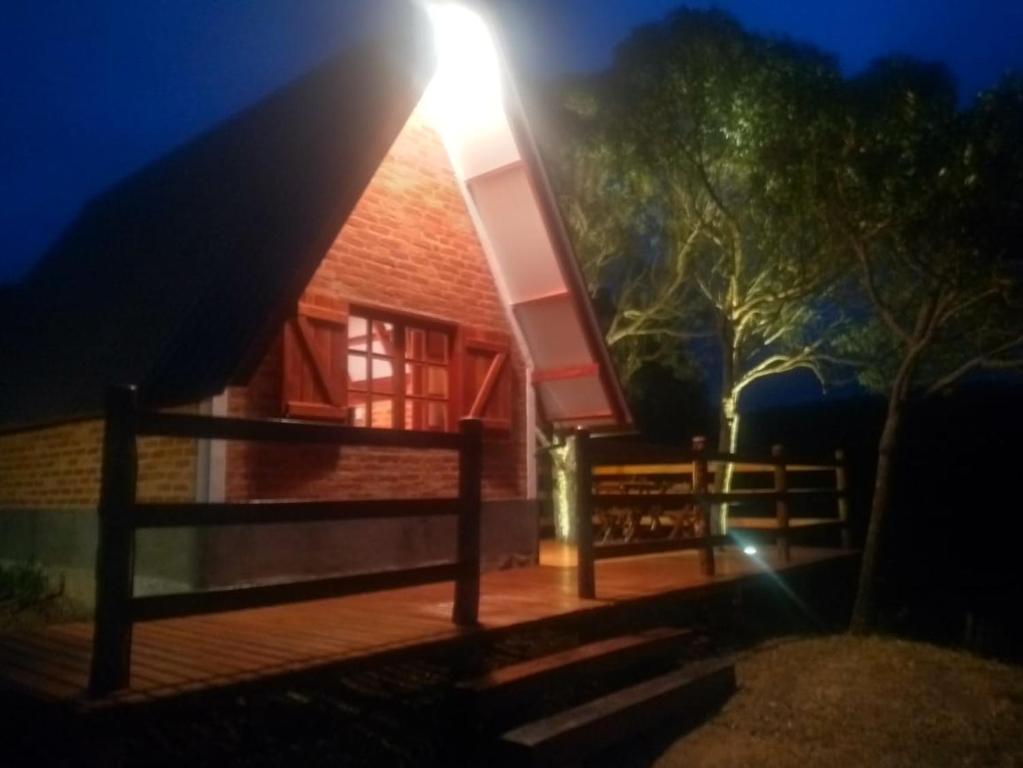 ein Licht scheint nachts auf die Vorderseite eines Hauses in der Unterkunft Pousada Cachoeira Esmeralda in Luminárias