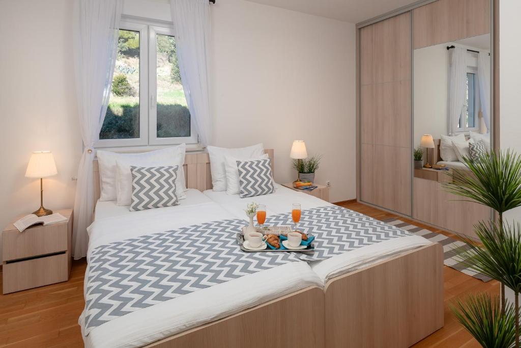 a bedroom with a large bed with a tray of food on it at Sun Spalato Hills in Split