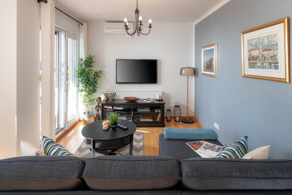 a living room with a couch and a tv at Sun Spalato Hills in Split