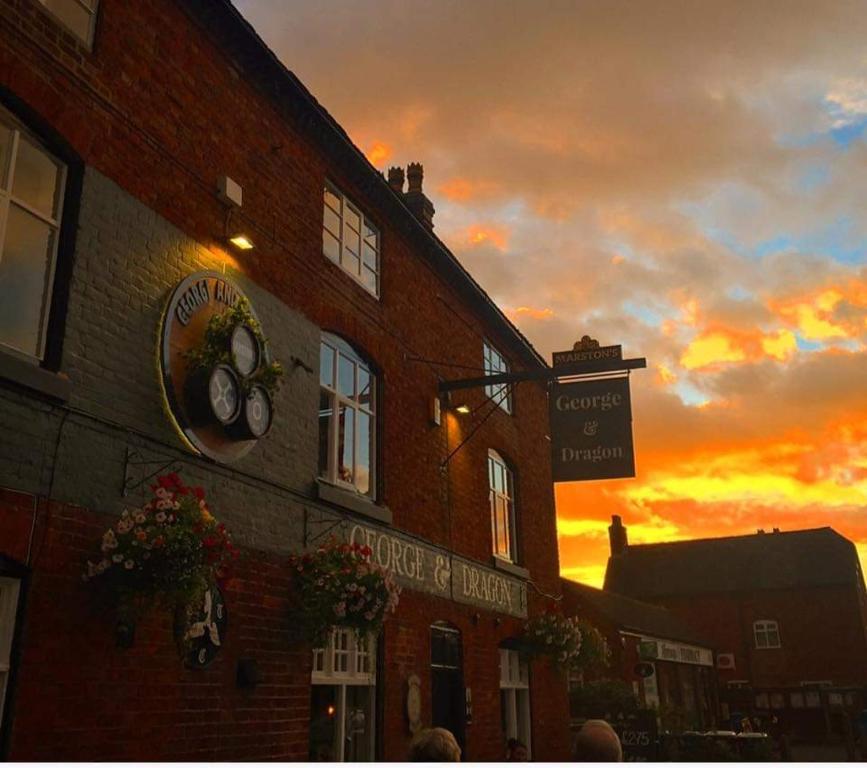 a building with a clock on the side of it at George and Dragon, Alrewas in Alrewas