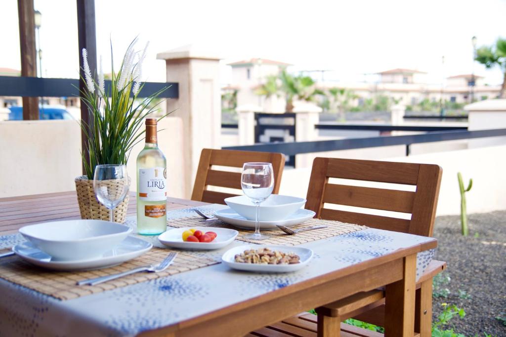a table with a bottle of wine and a plate of food at The Blue Torrent, perfect for relaxing getaway in La Oliva