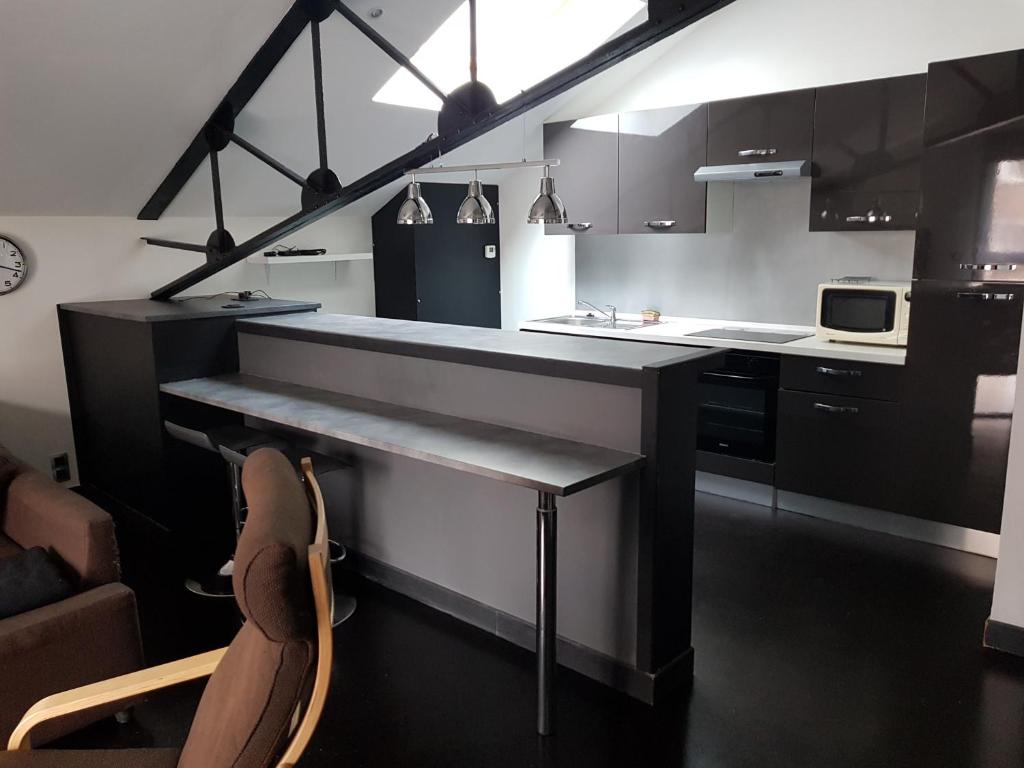 a kitchen with a counter and a table in it at APPARTEMENT LOFT CROIX LILLE in Croix