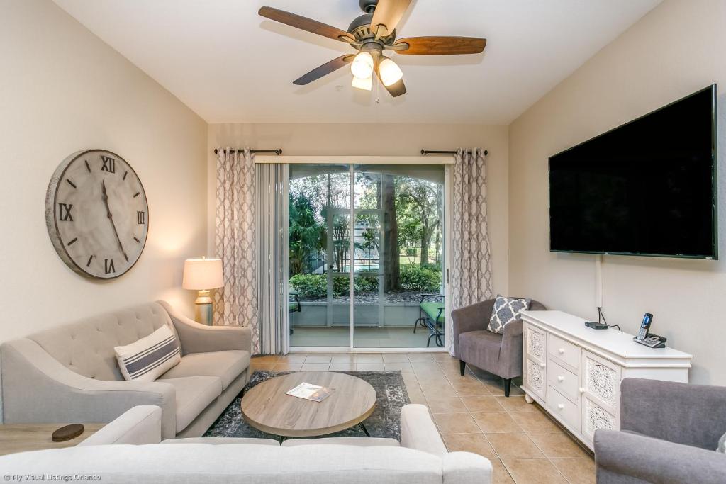 uma sala de estar com um relógio e uma televisão em Disney Bunk Room--Windsor Hills em Orlando