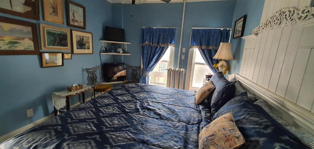 Un dormitorio con una cama con paredes azules y una ventana en A Moment in Time Bed and Breakfast en Niagara Falls