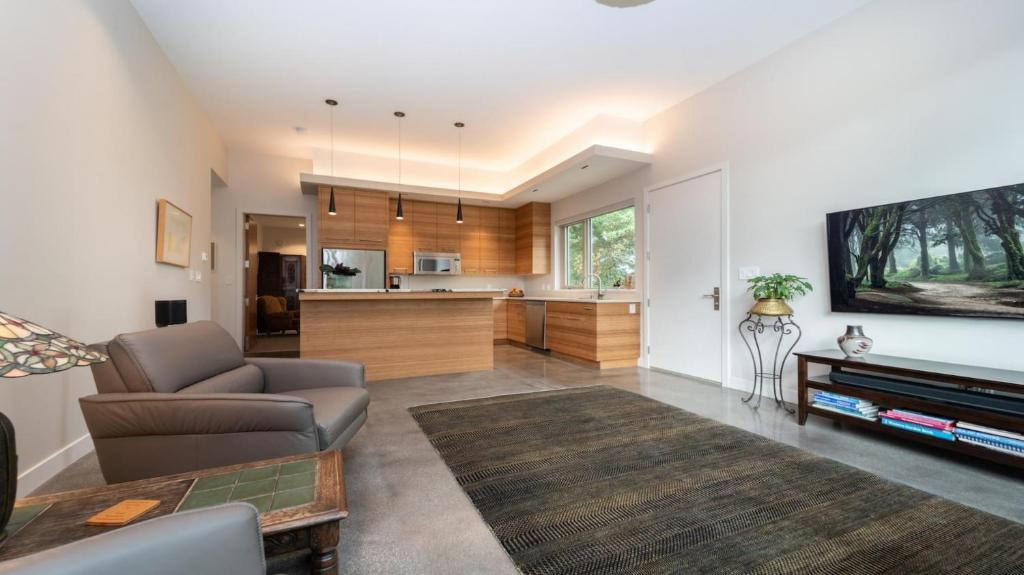 a living room with a couch and a kitchen at Private Modern Queenswood Suite in Victoria