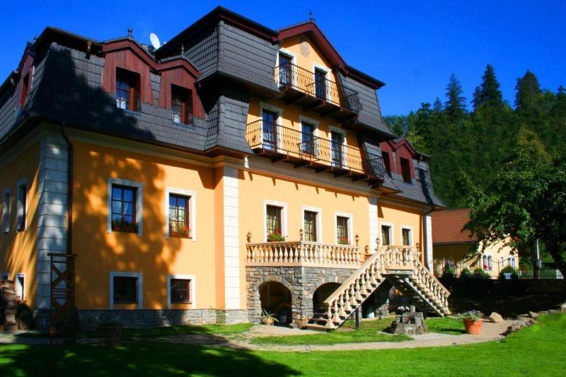 a large house with a staircase in front of it at Penzión Kastiel Hanus in Spišské Hanušovce