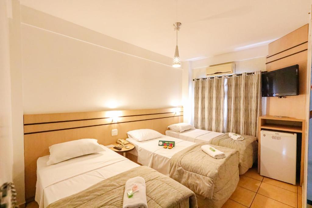 Habitación de hotel con 2 camas y TV en Hotel Villa Quati, en Foz do Iguaçu