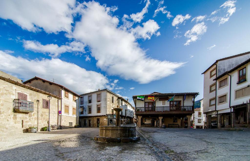 uma rua numa cidade velha com uma fonte de água em Casa Rural Las 6 Hermanas em São Martinho de Trevelho