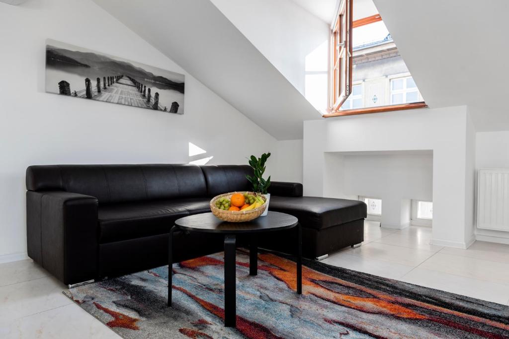 a living room with a black leather couch and a table at MK Apartment 100m2 Friends&Family in Krakow