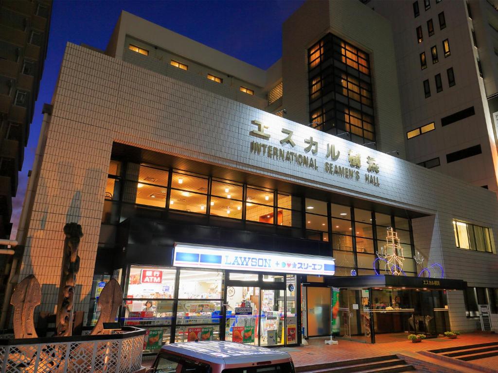 un bâtiment avec un panneau à l'avant dans l'établissement ESCALE-YOKOHAMA, à Yokohama