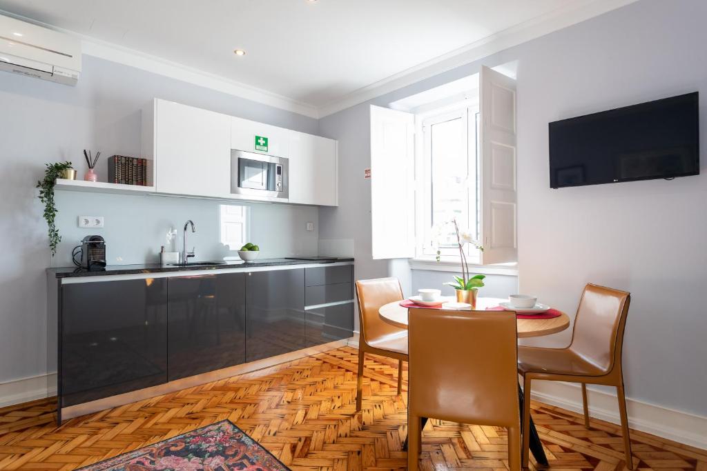 a kitchen and dining room with a table and chairs at Duques Villa Luxury Guesthouse in Lisbon