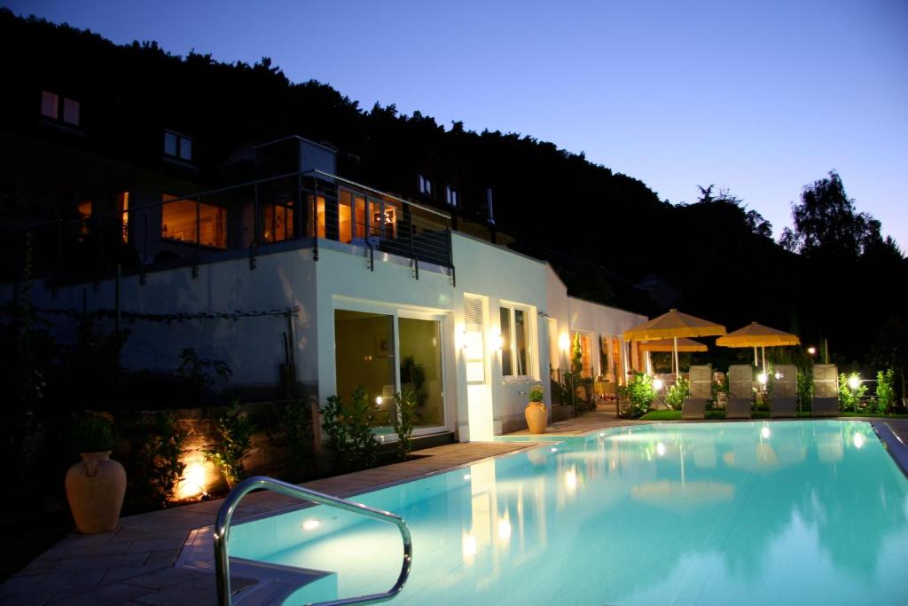 a swimming pool in front of a house at night at Wiedemann's Weinhotel in Sankt Martin