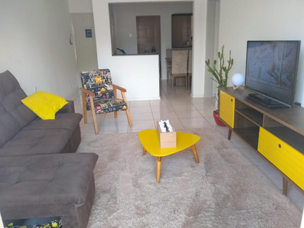 a living room with a couch and a tv at Quarto exclusivo em APTO compartilhado in Novo Hamburgo