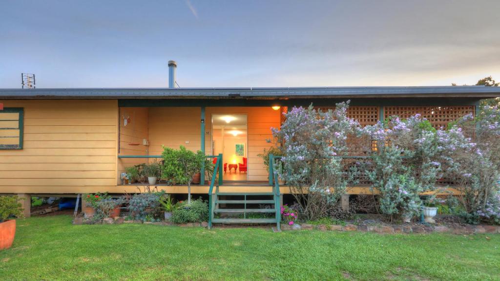 a house with a staircase in front of it at Village Stays Coldstream Gallery Bungalow in Ulmarra