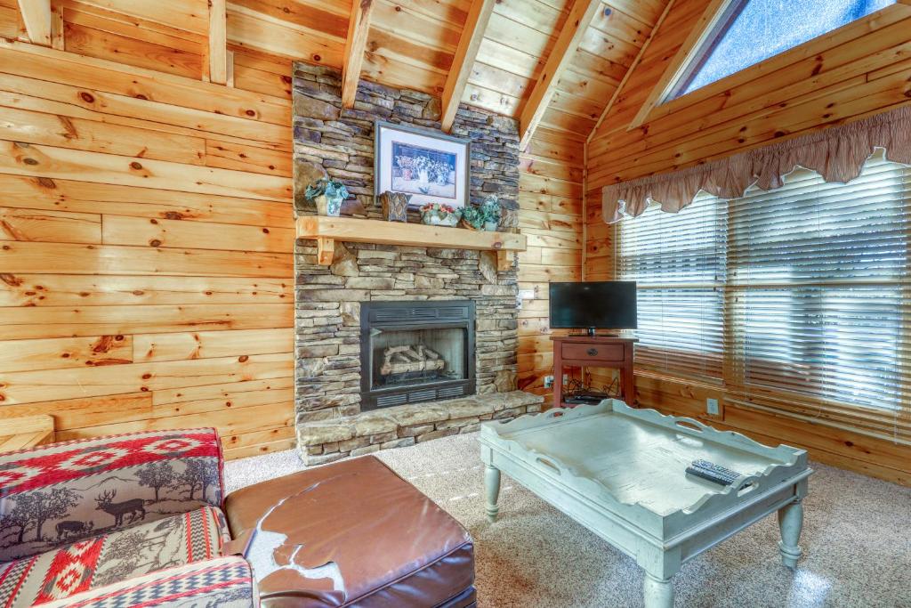 a living room with a fireplace in a log cabin at Almost Heaven in Pigeon Forge