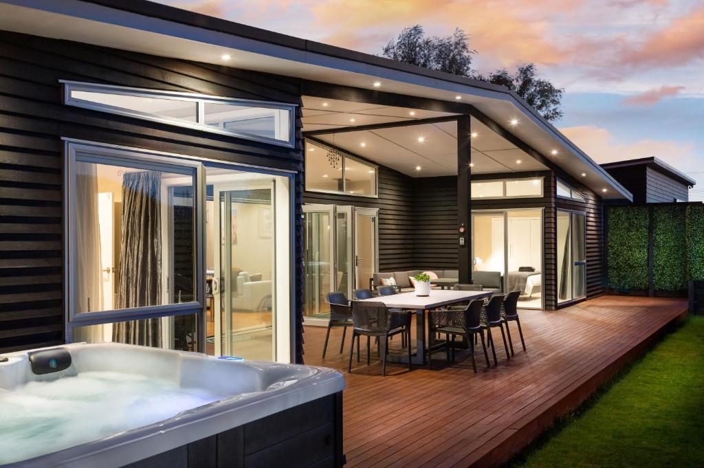 a modern house with a tub and a dining area at Wind Down on Esther in Martinborough 