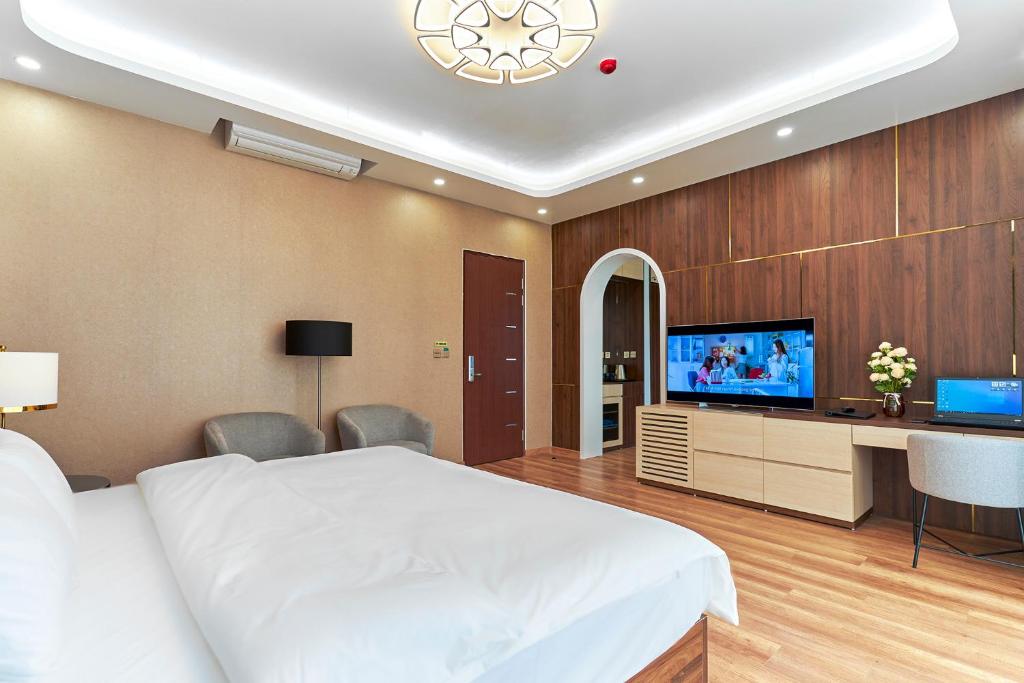 een slaapkamer met een bed en een flatscreen-tv bij BBQ Hostel Ha Long 2 in Ha Long