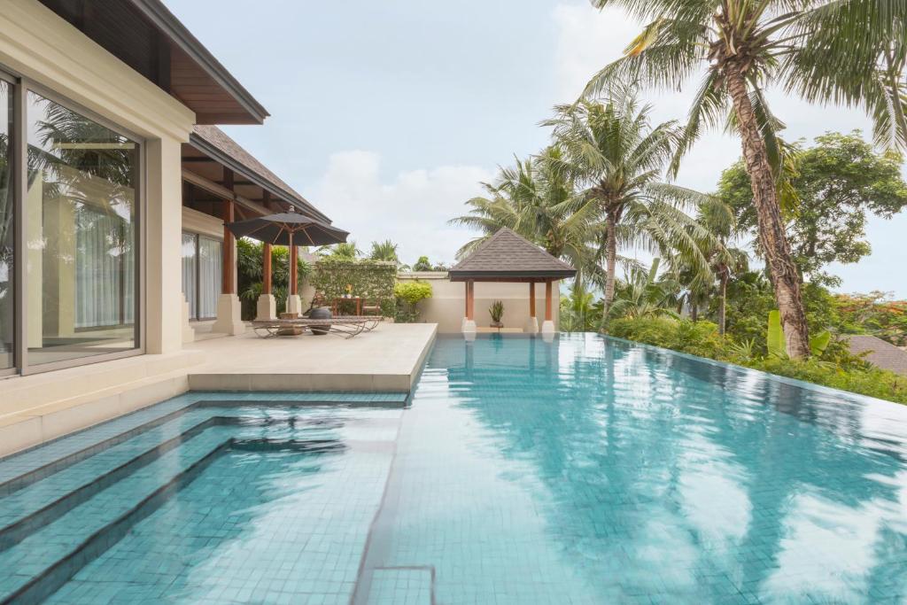 an infinity pool with a gazebo next to a house at The Pavilions Phuket in Bang Tao Beach