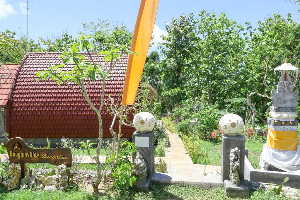 un jardín con una grúa frente a un edificio en Bougainvillea Bungalow, en Nusa Penida