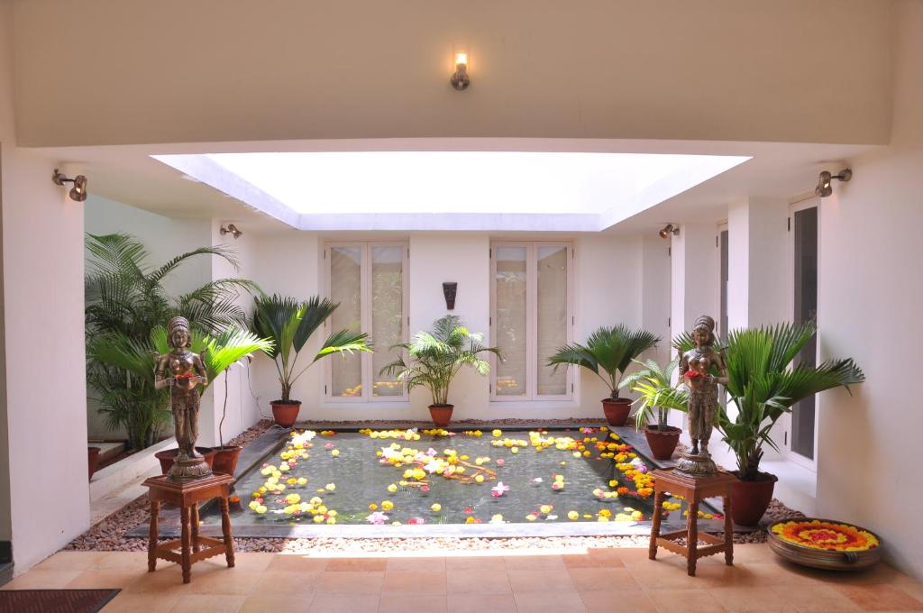 a large living room with a large pool with plants at Niketana @ Boat Club in Chennai