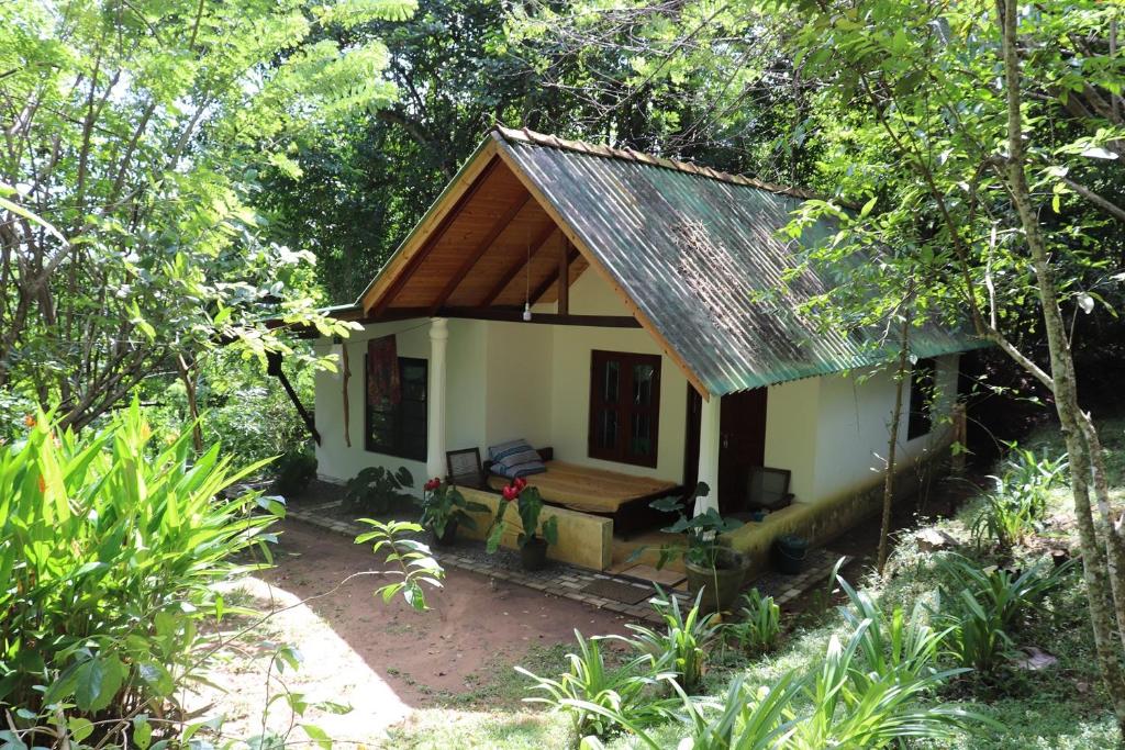 una pequeña casa en medio de un bosque en Green Hill Cottage, en Tangalle