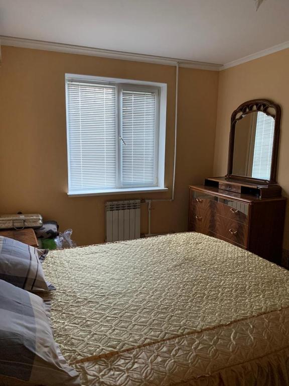 a bedroom with a bed and a dresser and a mirror at 139А Проспект Добровольского Уютная Трех Комнатная квартира в Одессе in Odesa