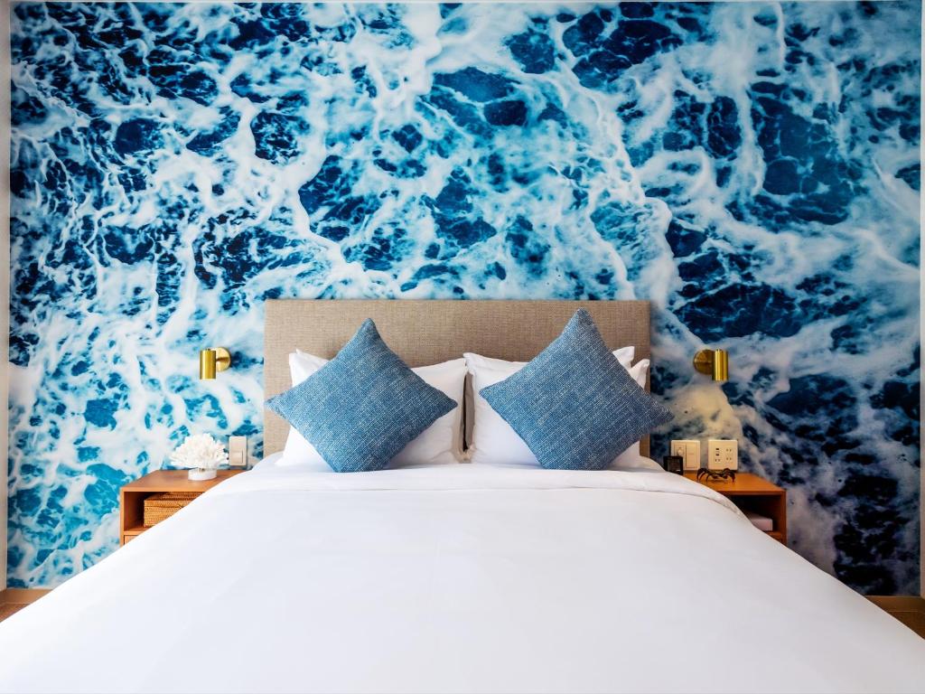 a bedroom with a bed with a blue and white wallpaper at The Moana by DSH Resorts in Chatan