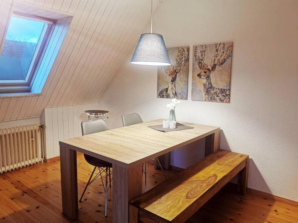 a dining room table with a bench and a light at Moderne Ferienwohnung in ruhiger Lage in Neetze